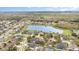 This aerial view showcases homes surrounding a lake in a wooded area with a golf course visible in the background at 2326 Wintermere Pointe Dr, Winter Garden, FL 34787