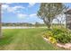The view from the backyard shows a green lawn that leads to a body of water and several other homes at 2326 Wintermere Pointe Dr, Winter Garden, FL 34787