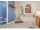 Bright bathroom featuring tile floors, enclosed shower, soaking tub, and blue accent wall at 2326 Wintermere Pointe Dr, Winter Garden, FL 34787
