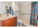 Bathroom with a shower behind a floral curtain, a white toilet and a wooden sink vanity at 2326 Wintermere Pointe Dr, Winter Garden, FL 34787