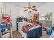 Bedroom featuring a ceiling fan and a blue bed frame with a colorful quilt and shelving unit at 2326 Wintermere Pointe Dr, Winter Garden, FL 34787