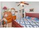 Comfortable bedroom featuring wood dresser, ceiling fan, and red wood bed frame with blue and white quilt at 2326 Wintermere Pointe Dr, Winter Garden, FL 34787