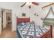 Cozy bedroom with red wood bed frame, a quilt with blue hearts, and a ceiling fan with lights at 2326 Wintermere Pointe Dr, Winter Garden, FL 34787