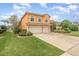 Two story home with a terracotta tiled roof, an attached two car garage, and well-manicured landscaping at 2326 Wintermere Pointe Dr, Winter Garden, FL 34787