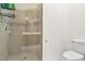 Bathroom featuring a tiled shower with a glass door and a standard white toilet at 2333 Pesaro Cir, Ocoee, FL 34761