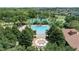 Aerial view of a community pool and recreation area surrounded by mature trees, manicured lawns, and tennis courts at 2333 Pesaro Cir, Ocoee, FL 34761