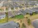 An aerial view showing a neighborhood with neatly arranged homes, green lawns, and a tranquil pond nearby at 2949 Marlberry Ln, Clermont, FL 34714