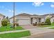 Inviting single-story home boasting a manicured lawn, a two-car garage, and a covered entryway at 2949 Marlberry Ln, Clermont, FL 34714