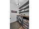 Modern laundry room with gray washer and dryer, wood countertop, floating shelves, and decorative sign at 2949 Marlberry Ln, Clermont, FL 34714