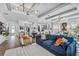 Open-concept living area with modern lighting, wood floors, and a blue velvet sofa at 2949 Marlberry Ln, Clermont, FL 34714