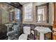 Bathroom with a pedestal sink, dark stone shower and tiling, a window with blinds at 3414 Cocard Ct, Windermere, FL 34786