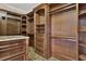 Walk-in closet with custom wood shelving, drawers, and granite countertop island at 3414 Cocard Ct, Windermere, FL 34786