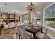 Formal dining area with hardwood table, chandelier lighting, and natural light streaming through window at 3414 Cocard Ct, Windermere, FL 34786