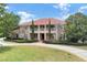 Stunning two-story home boasting a terracotta roof, lush landscaping, and a circular driveway at 3414 Cocard Ct, Windermere, FL 34786