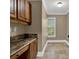 Laundry room featuring granite countertops, tile floor, and wood cabinets at 3414 Cocard Ct, Windermere, FL 34786