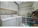 Laundry room features overhead storage cabinets, hanging racks and side shelving for cleaning supplies at 3430 Laurel Dr, Mount Dora, FL 32757