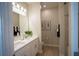Bright bathroom featuring double sinks, modern fixtures, and a glass-enclosed shower providing a clean and refreshing experience at 3864 Bluethread Way, Poinciana, FL 34759