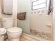 Bathroom featuring a tiled walk-in shower, toilet, and frosted glass panel at 418 S Summerlin Ave, Sanford, FL 32771
