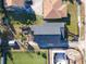 Overhead view of the home with a dark roof, patio space, mature trees, and manicured landscape at 434 E Harding St, Orlando, FL 32806