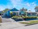 Blue home features a lush front yard, a charming front porch, and a long driveway, all combining for great curb appeal at 434 E Harding St, Orlando, FL 32806