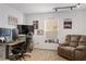 Home office features a large computer setup and cozy sitting area with neutral carpeting and natural light at 5278 Walnut Ridge Dr, Orlando, FL 32829