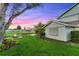 A serene backyard featuring a cozy fire pit area, lush green grass, and charming string lights at 53 Fore Dr, New Smyrna Beach, FL 32168
