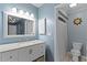 Charming bathroom with blue walls, decorative mirror, sink, and a toilet with a shower and tub combo at 53 Fore Dr, New Smyrna Beach, FL 32168