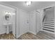 Bright entryway leading to the bathroom and stairs, featuring wood-look flooring at 53 Fore Dr, New Smyrna Beach, FL 32168