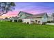 Charming home featuring a two-car garage, lush lawn, and tastefully landscaped with colorful plantings at 53 Fore Dr, New Smyrna Beach, FL 32168
