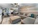 Spacious living room with modern gray couch, ottoman, area rug, and open kitchen with gray cabinets at 53 Fore Dr, New Smyrna Beach, FL 32168