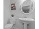 Bright powder room featuring a pedestal sink, toilet, neutral paint and a decorative mirror at 53 Fore Dr, New Smyrna Beach, FL 32168