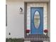 Close-up of the home's front door, with decorative stonework and a colorful potted flower arrangement at 655 E Lake View Rd, Lake Alfred, FL 33850
