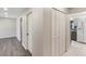 Hallway with wood-look floors and closet, leading to a kitchen with gray cabinets at 655 E Lake View Rd, Lake Alfred, FL 33850