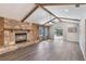 Spacious living room featuring a stone fireplace, high vaulted ceilings with wood beams, and hardwood floors at 655 E Lake View Rd, Lake Alfred, FL 33850