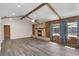 Spacious living room featuring a stone fireplace, high vaulted ceilings with wood beams, and hardwood floors at 655 E Lake View Rd, Lake Alfred, FL 33850