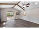 Bright living room with vaulted ceilings, wood beams, and sliding glass doors leading to the patio at 655 E Lake View Rd, Lake Alfred, FL 33850