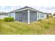Screened in patio, partially showing a lawn with green grass and an adjacent building at 7412 Sw 76Th Ter, Ocala, FL 34481