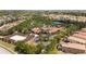 Aerial view of clubhouse and pool, palm trees, and sand volleyball court nestled among the community homes at 7630 Oakmoss Loop, Davenport, FL 33837