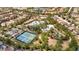 An aerial view of the community pool, tennis courts, lazy river, and luxurious clubhouse amid lush landscaping at 7630 Oakmoss Loop, Davenport, FL 33837