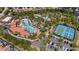 Aerial view of community pool, tennis courts, parking and luxurious clubhouse surrounded by lush landscaping at 7630 Oakmoss Loop, Davenport, FL 33837