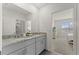 Bathroom featuring double sinks, granite countertops, and ensuite bedroom access at 7630 Oakmoss Loop, Davenport, FL 33837