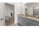 Bathroom featuring double sinks, granite countertops, an ensuite bathroom and bedroom access at 7630 Oakmoss Loop, Davenport, FL 33837