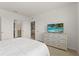 Bedroom with neutral walls and carpet, an ensuite bathroom, and a flatscreen television at 7630 Oakmoss Loop, Davenport, FL 33837