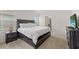 Bedroom boasts a rustic wood bed frame, a flatscreen television, and neutral colored carpet at 7630 Oakmoss Loop, Davenport, FL 33837