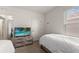 Bright bedroom featuring a dresser and television at 7630 Oakmoss Loop, Davenport, FL 33837