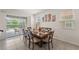 Dining area with access to the lanai and pool, featuring a large table and stylish decor at 7630 Oakmoss Loop, Davenport, FL 33837