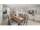 Open-concept dining area with a rustic wood table, seating for eight, and seamless flow to the kitchen at 7630 Oakmoss Loop, Davenport, FL 33837