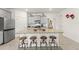 Bright kitchen featuring a large island with barstool seating, granite countertops and stainless steel appliances at 7630 Oakmoss Loop, Davenport, FL 33837