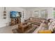 Comfortable living room with a plush sectional sofa, rustic coffee table, and natural light at 7630 Oakmoss Loop, Davenport, FL 33837