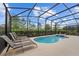The screened-in pool area has a hot tub and lounge chairs, perfect for relaxation at 7630 Oakmoss Loop, Davenport, FL 33837